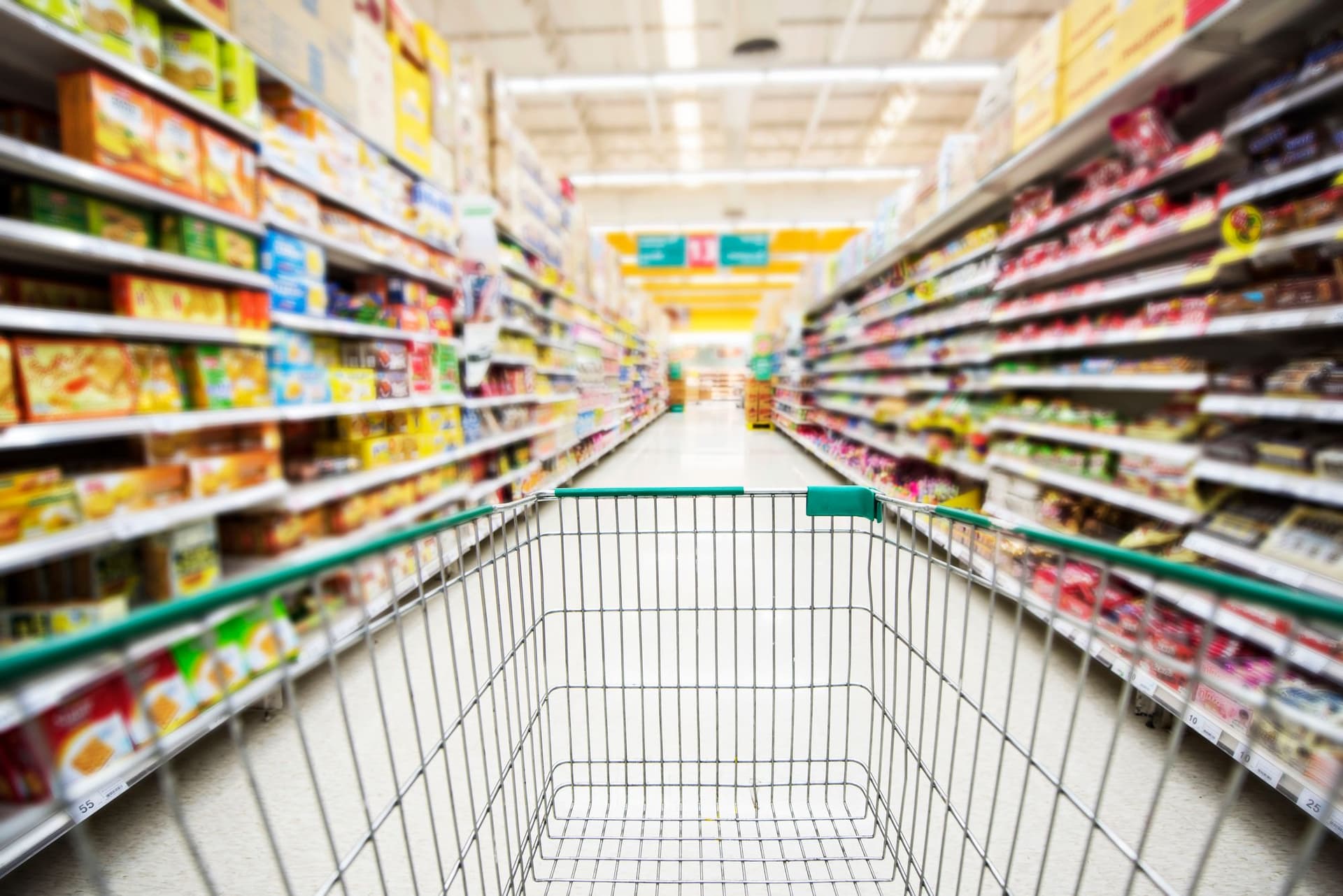 Shopping cart among the shelves of a supermarket