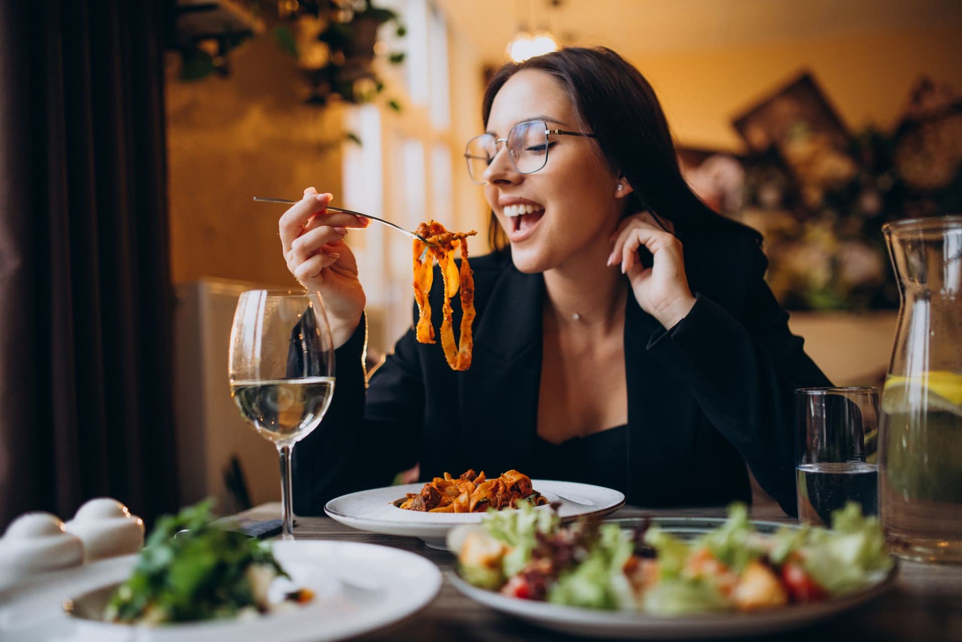 Young woman while eating pasta at the restaurant