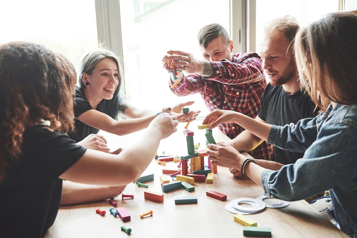 Group of creative friends having fun while playing a board game